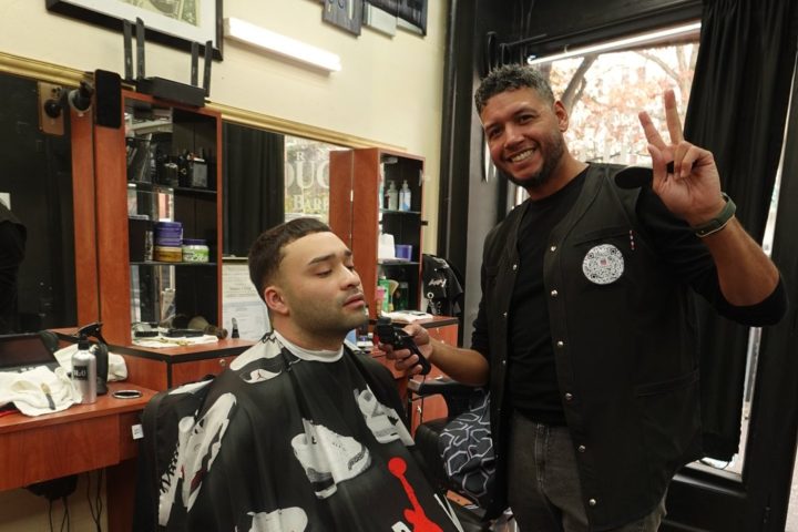 A barber at work with a client at Touch Ups Barbershop on South Broadway
